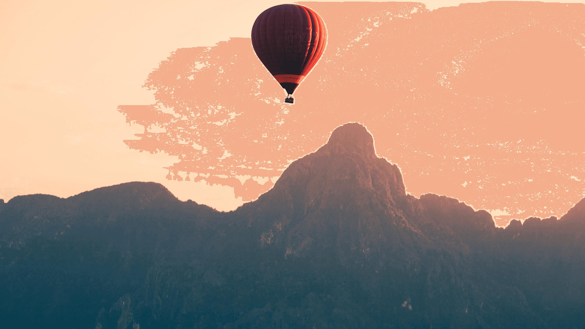 A hot-air balloon drifting over limestone peaks at sunrise
