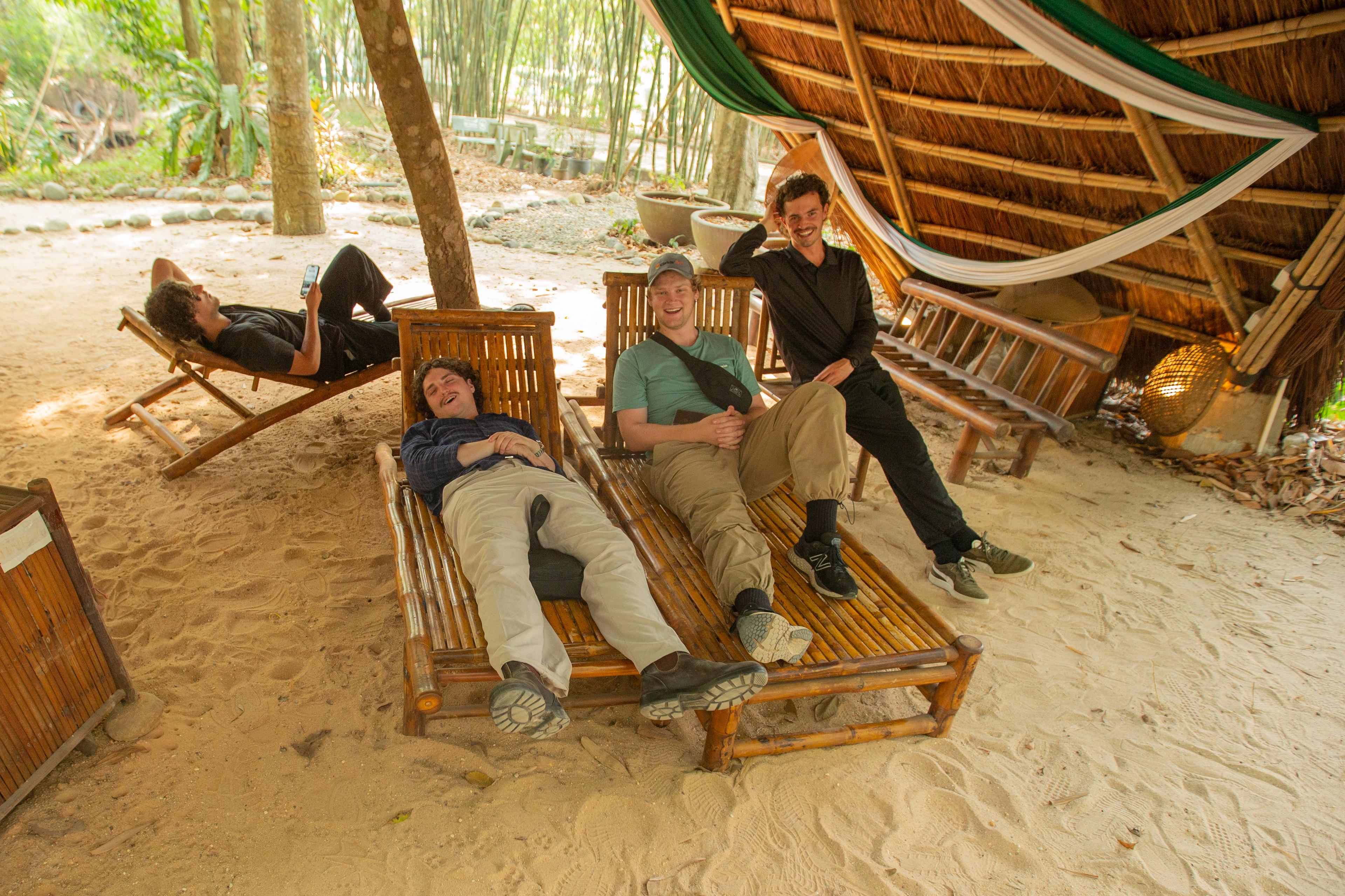 Guests relaxing on bamboo deckchairs by the beach
