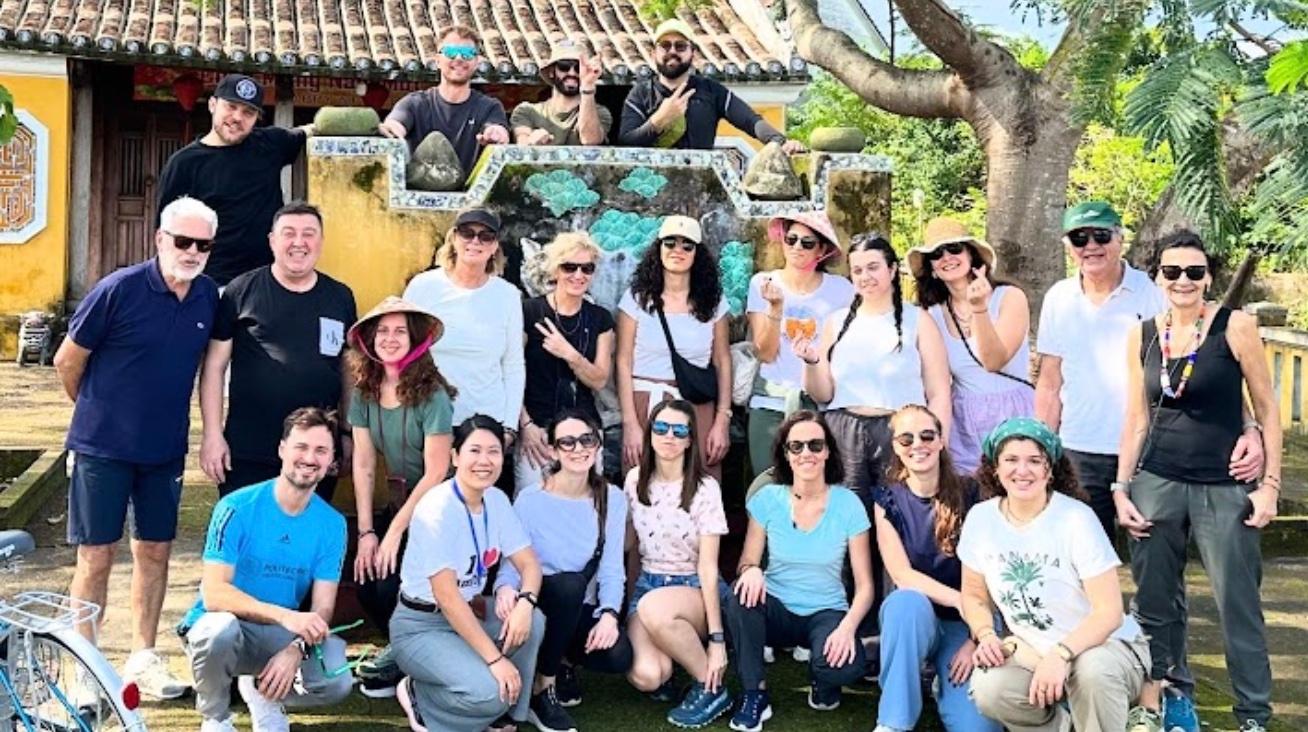 Gruppo di viaggiatori in posa davanti a una casa gialla della città vecchia