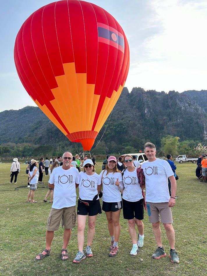 Famiglia in maglietta coordinata davanti a una mongolfiera, in Laos