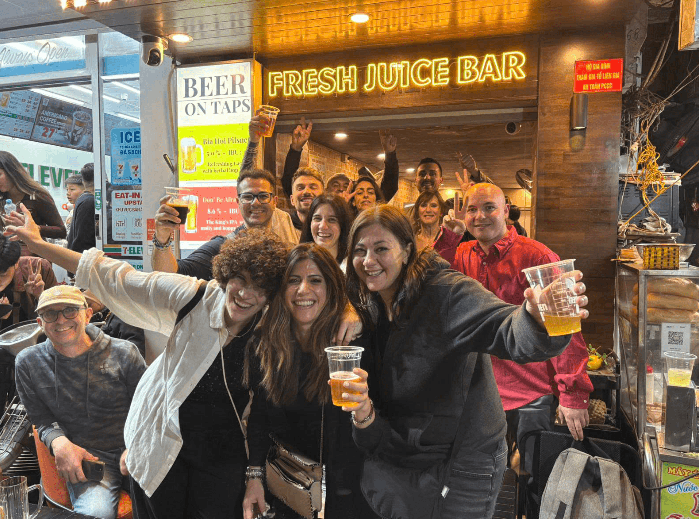 Gruppo con i bicchieri di birra in un locale della città vecchia di Hanoi