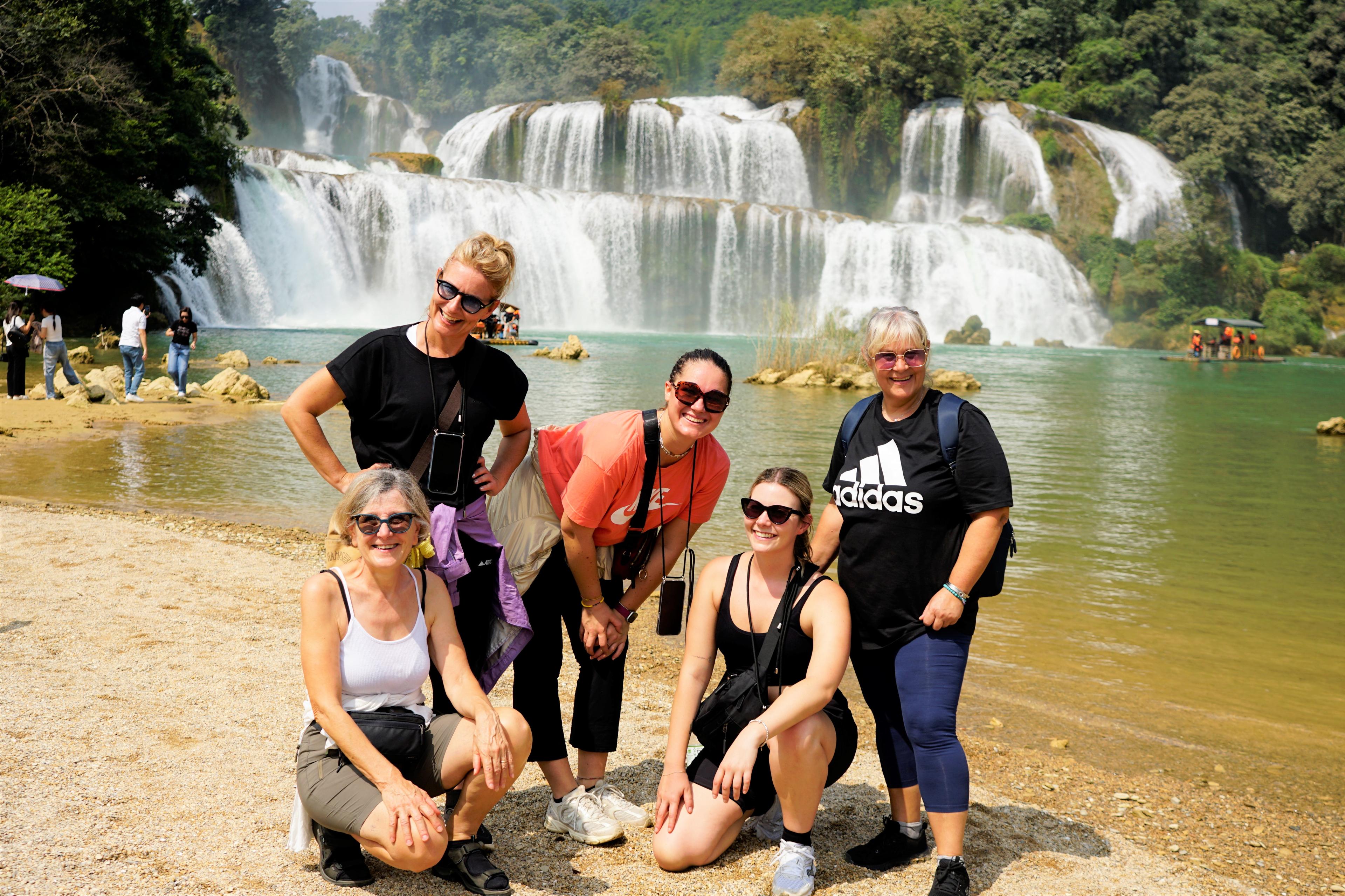 Quattro viaggiatrici davanti a una grande cascata