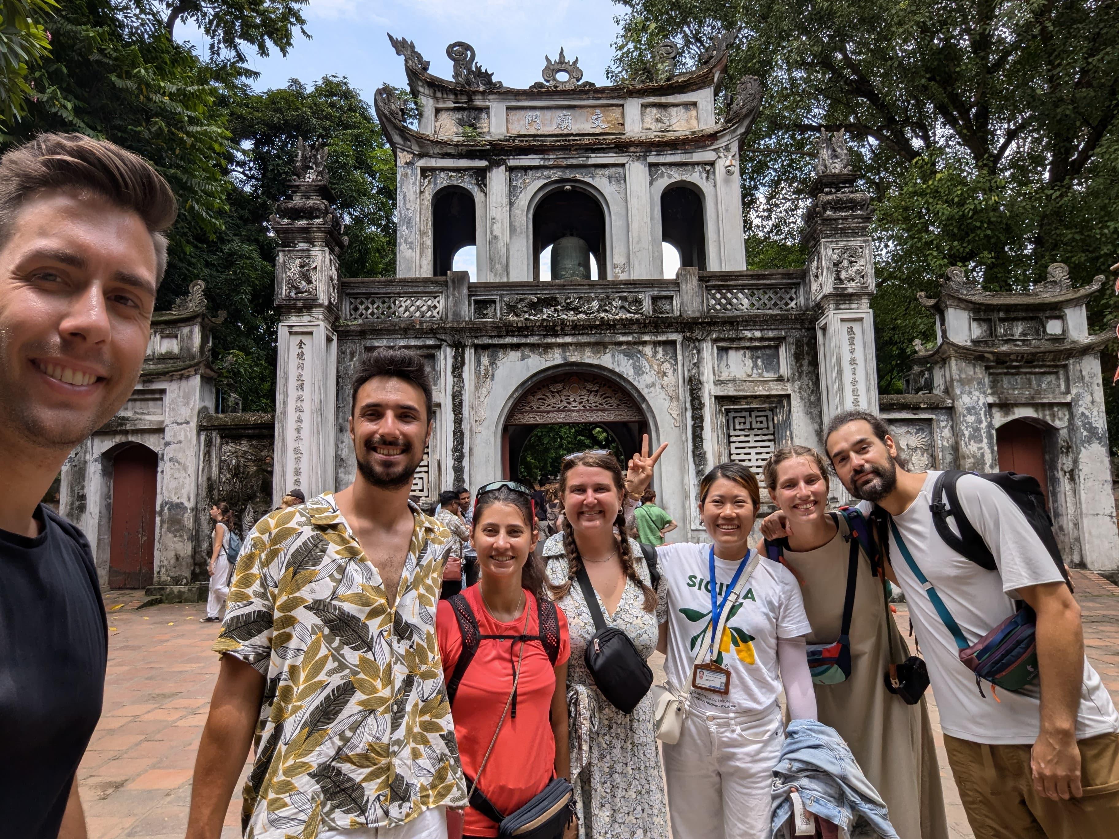 Gruppo di giovani viaggiatori davanti alla porta del Tempio della Letteratura, ad Hanoi
