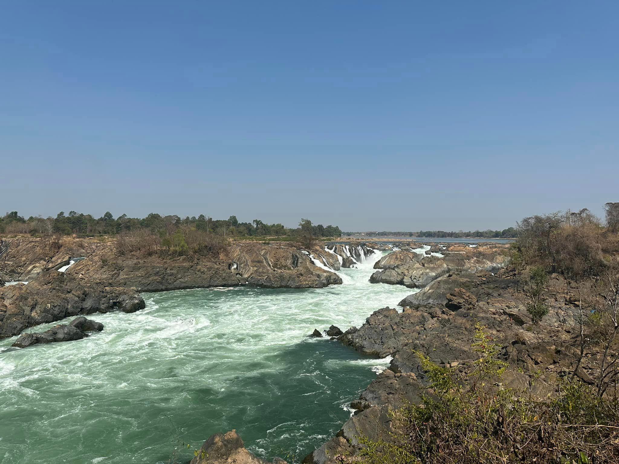 A wide river breaking into rapids and falls between rocky islands